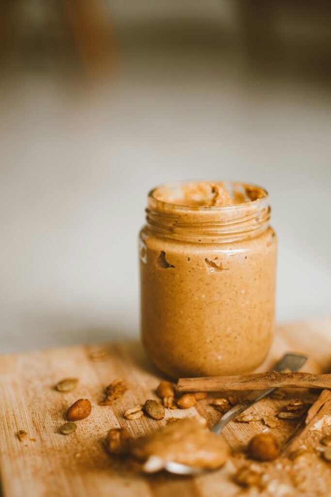 Jar of peanut butter with oats on a wooden table – a prepper pantry staple and survival food.