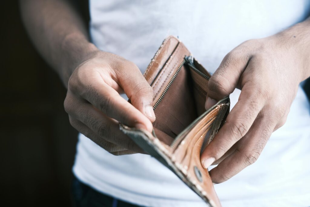 Person counting worn cash bills during an economic collapse, symbolizing financial breakdown and survival planning.