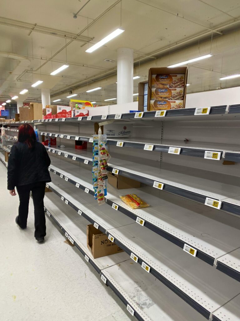 Man walking through empty grocery store shelves during a supply chain collapse – how to prepare for supply chain collapse