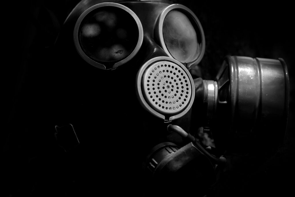 Prepper wearing a gas mask in a dark room during nuclear survival training