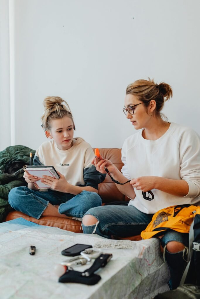 Family creating a home emergency communication plan together with printed checklist and phones