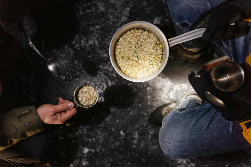 Cooking oats over a campfire, showing practical long term food storage and survival food preparation outdoors.