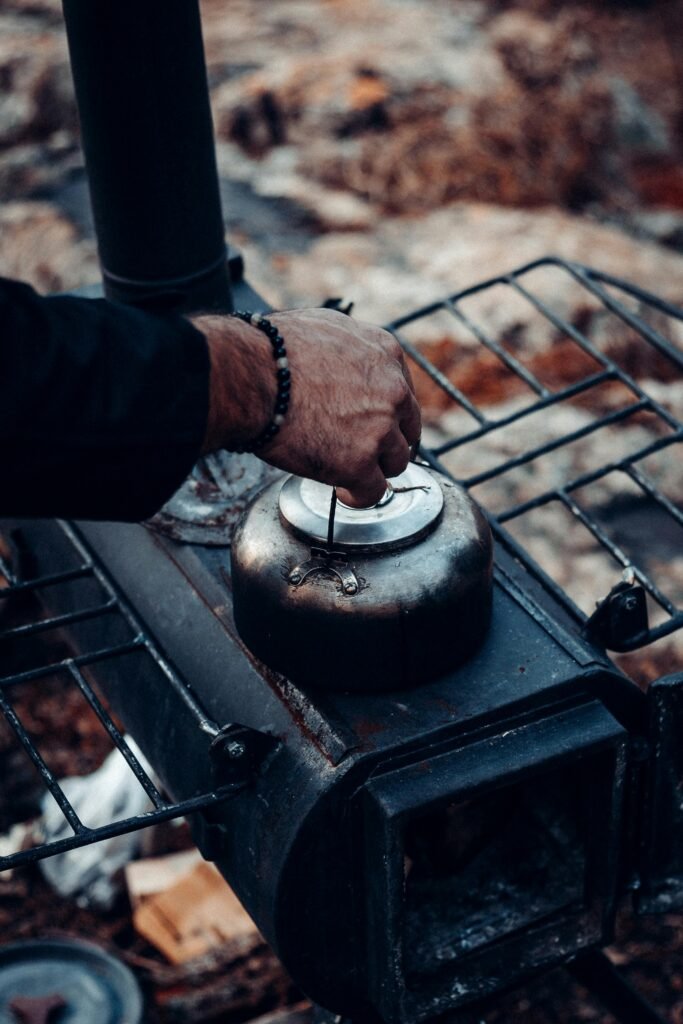 water prepping | Backyard Bug Out Person boiling water on a camp stove as part of emergency water prepping and purification.