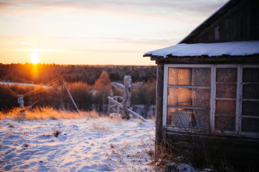 Mini ice age prepping cabin in winter sunrise — survival shelter ready for next big freeze